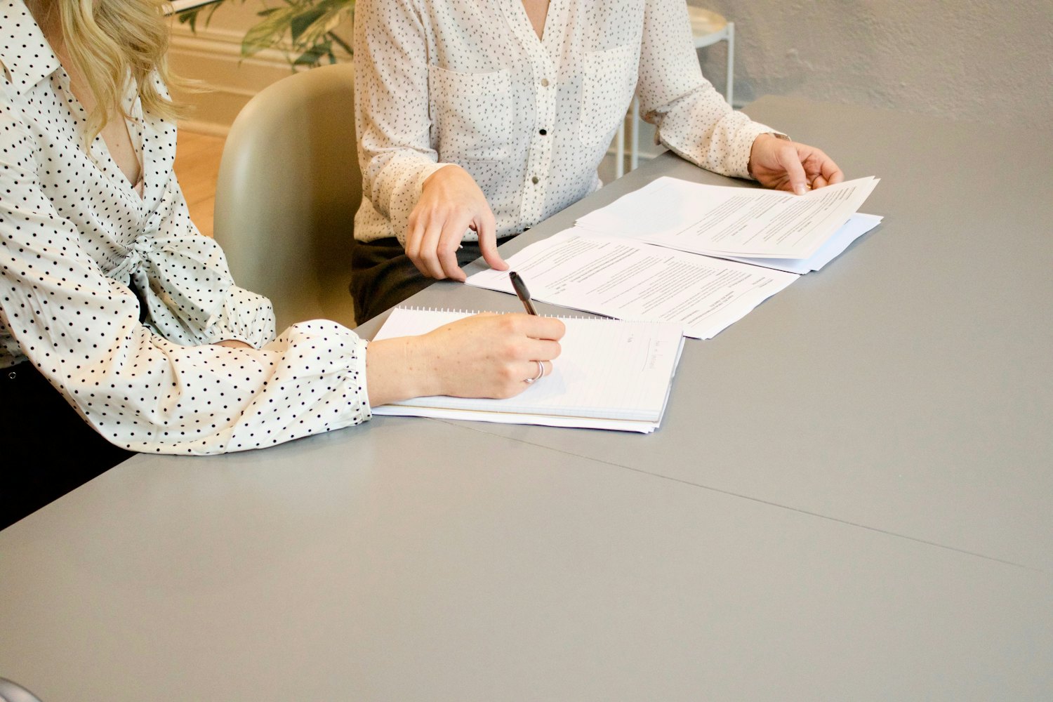 A client signs an agreement while the professional points to where to sign.